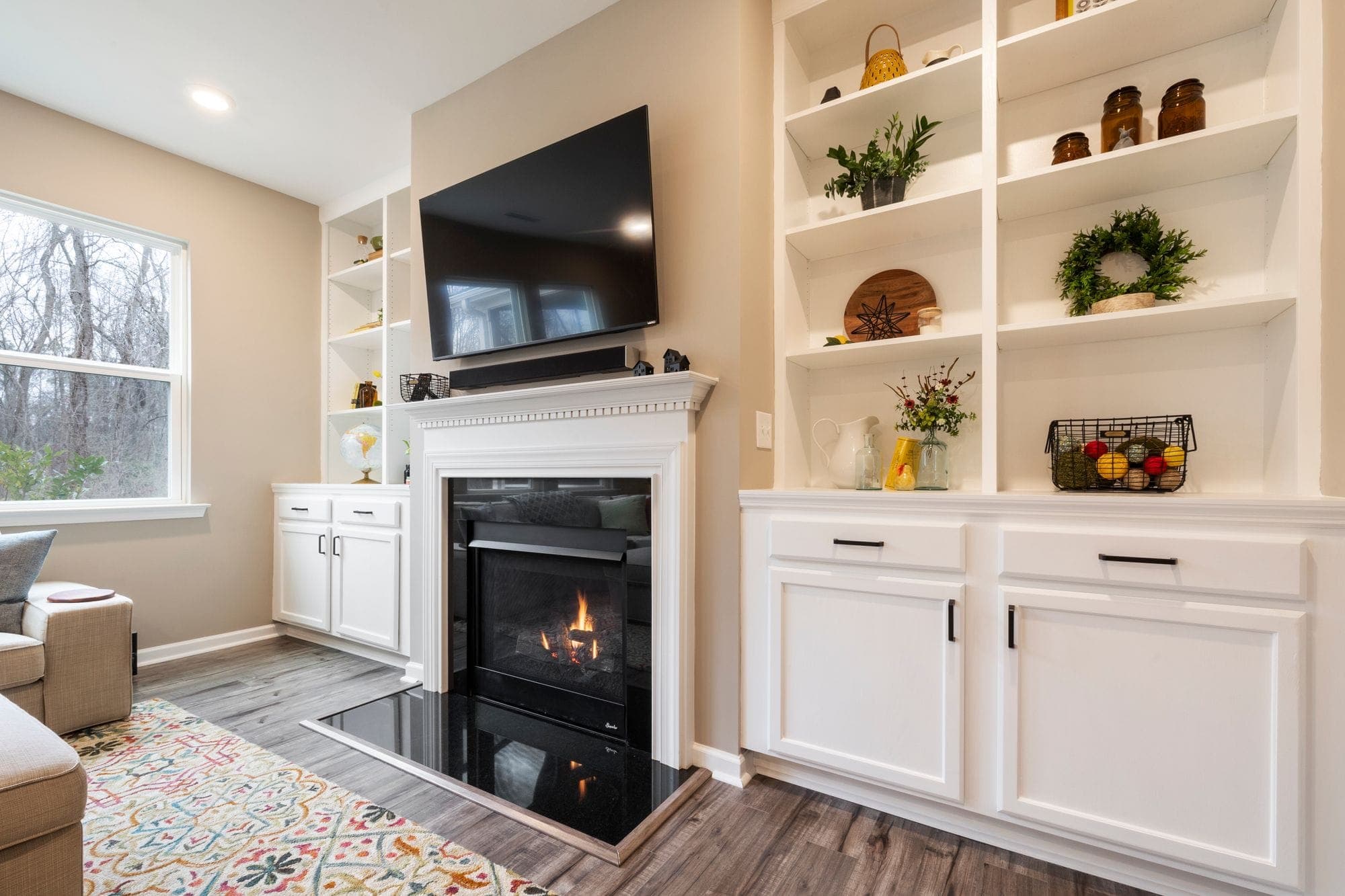 Warm finished den with a fireplace, built-ins, and a mounted TV
